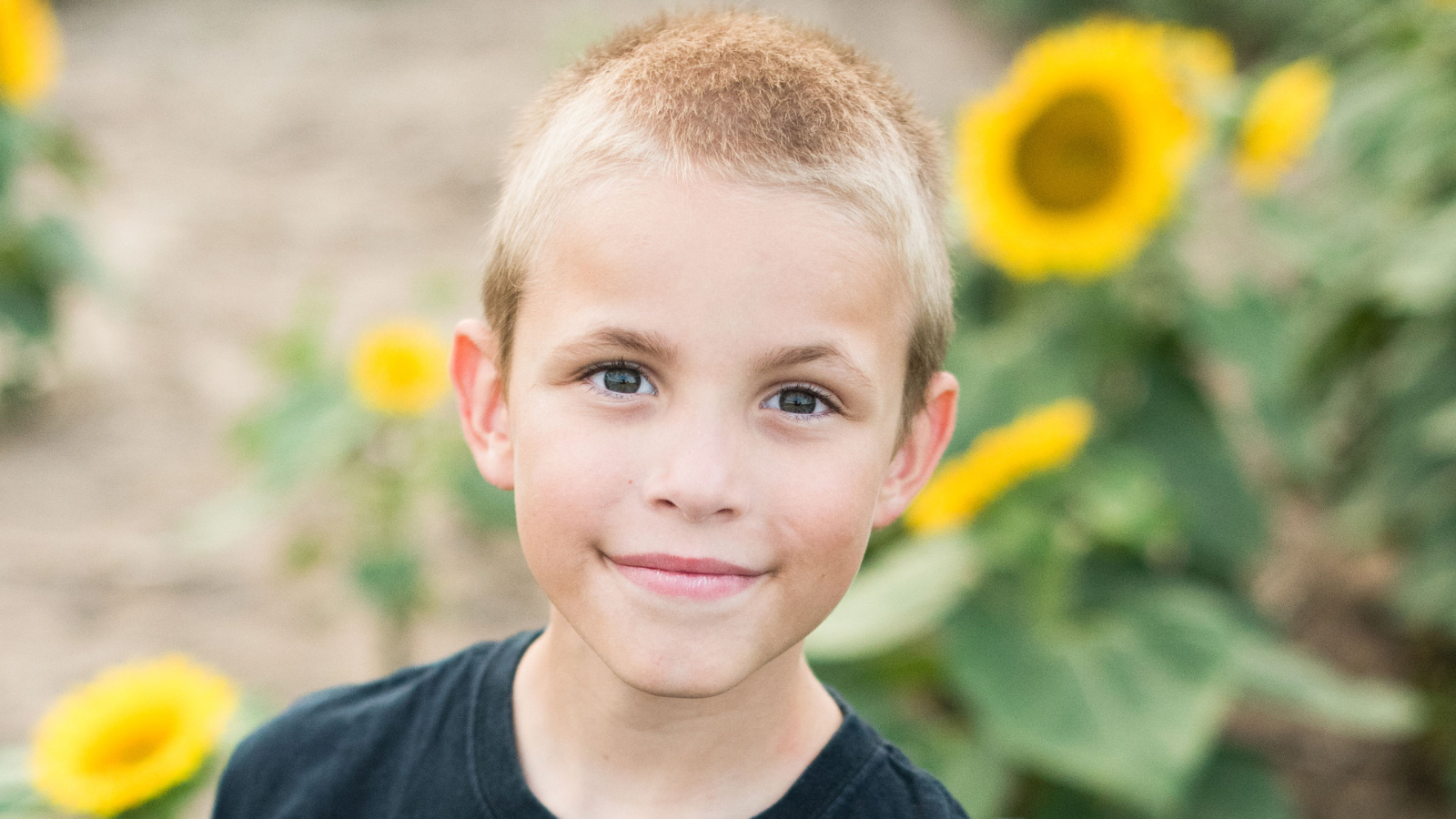 Matthew, le fils de Gillian, souriant dans un champ de tournesols.